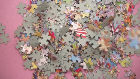 Many-Puzzle-Pieces-Falling-Down-On-Pink-Background---overhead-view