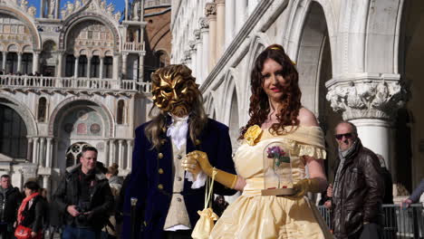 Beautiful-couple-of-lovers-standing-together-with-ornamental-mask-in-piazza-san-marco,-venezia-during-the-famous-carnival-traditional-holiday
