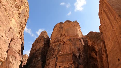 Looking-at-the-cloudscape-above-the-sandstone-cliffs-and-ancient-tombs-in-Petra,-Jordan---time-lapse