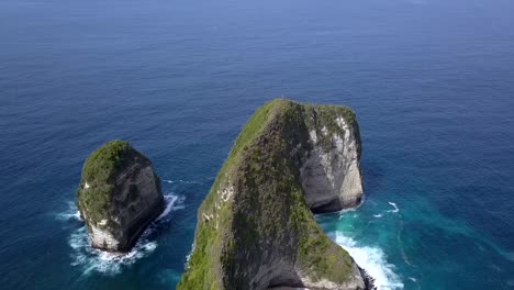 Spectacular-aerial-view-flight-circle-drone-shot-of-mystic-magic-island-in-ocean-Kelingking-Beach-at-Nusa-Penida-in-Bali-Indonesia-is-Jurassic-Park-Cinematic-nature-cliff-view-above-by-Philipp-Marnitz