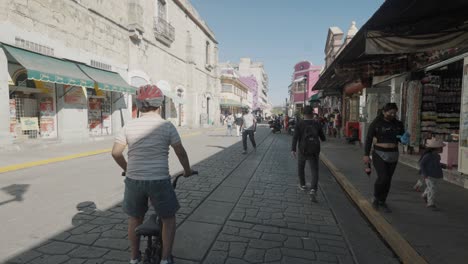 Kind-Fährt-Fahrrad-Und-Menschen-Gehen-Durch-Die-Straßen-Von-Oaxaca,-Mexiko