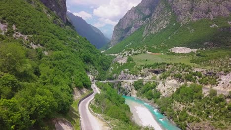 Winding-road-alongside-a-blue-river-in-the-beautiful-Valbona-Kukes-of-the-Albanian-Alps,-Eastern-Europe