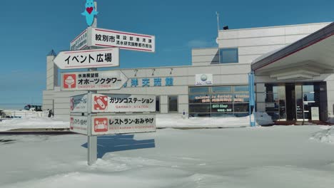 Informationstafeln-Vor-Dem-Eingang-Der-Garinko-Go-Station,-Umgeben-Von-Schnee-In-Hokkaido