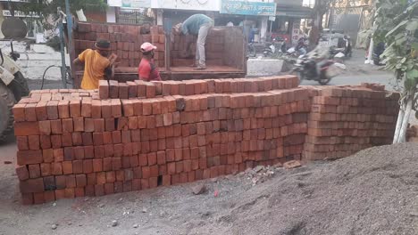 Indian-workers-unloaded-bricks-from-the-tractor-at-the-construction-site