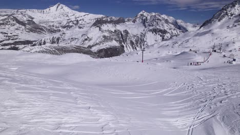 Drohnenansicht-Einer-Wunderschönen-Bergwelt-Mit-Skifahrern-–-Kippaufnahme-Und-Dolly-In-Der-Aufnahme-–-Aufnahme-In-Tignes-Und-Val-D&#39;Isere