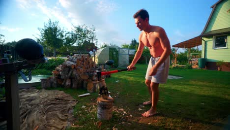 Portrait-Of-A-Young-Man-Chopping-Wood-In-The-Backyard-At-Summer