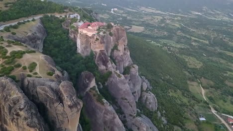 Retreating-aerial-of-monastery-atop-high-rock-cliff-in-Meteora,-Greece