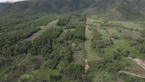 Drone-Desciende-A-Casa-De-Campo-En-Un-Exuberante-Valle-Verde-En-El-Centro-De-Perú