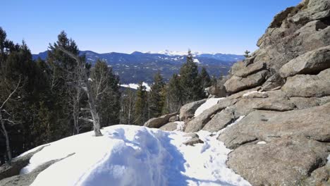 Snowy-hiking-trail-through-rocky-terrain-with-Mt-Evans-in-the-distance,-Colorado