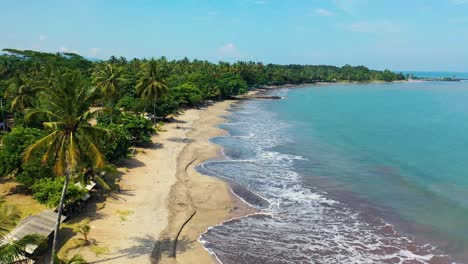 Aerial-view-of-a-beach-in-a-tropical-island,-drone-still-shot-of-the-seashore-coastline-during-a-sunny-day
