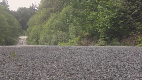Kia-Rio-Hatchback-driving-fast-on-dirt-gravel-forest-road-on-a-mountain-trail-in-Squamish-BC