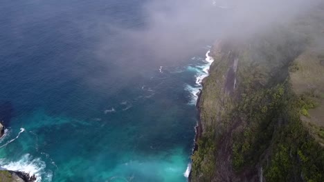 Wundervoller-Flug-Mit-Schwebedrohne-Aus-Der-Luft,-Aufgenommen-über-Wolken-Hoch-Im-Himmel.-Der-Kelingking-Strand-Auf-Nusa-Penida-Auf-Bali,-Indonesien,-Ist-Wie-Jurassic-Park
