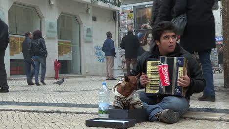 He-is-15-years-old,-he-is-a-beggar-and-with-the-accordion-in-his-arms,-he-plays-for-the-tourists-who-walk,-by-his-side-the-small-dog-that-accompanies-him-every-day