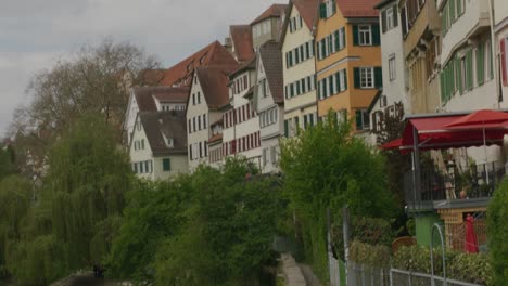 Pan-up-view-from-river-to-sky-in-downtown-Tubingen-historic-district-in-Balvaria-at-noon,-Germany,-Europe