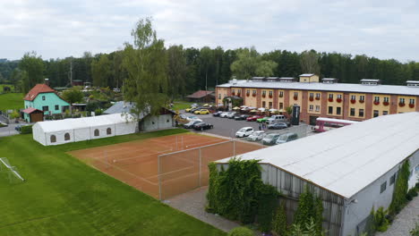 Luxurious-sports-cars-parked-at-tennis-resort-with-courts,-Czechia
