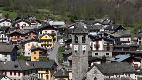 A-dynamic-aerial-tracking-footage-of-the-clock-tower-in-the-middle-of-the-town-of-Villadossola,-Domodossola,-and-Simplon-pass