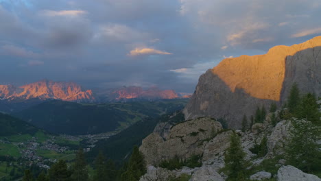 Impresionante-Paisaje-De-Montaña-Rocosa-Del-Tirol-Del-Sur-Iluminado-Vista-Inversa-Aérea-De-La-Puesta-De-Sol-Brillando-En-Picos-Escarpados