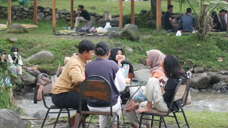 Yogyakarta,-Indonesia---May-26,-2022-:-Group-of-young-Asian-people-picnicking-around-the-river-with-fresh-view