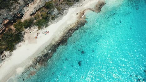 View-of-drone-from-above-of-friends-on-the-1000-steps-beach-in-Bonaire,-Dutch-Caribbean,-South-America