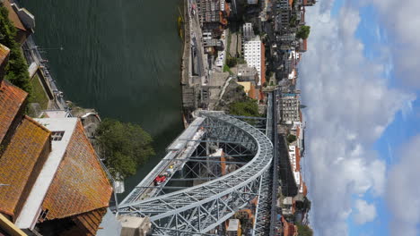 Vertical-Shot-Of-Dom-Luis-I-Bridge-Over-Douro-River-And-Porto-Cityscape-In-Portugal-At-Daytime