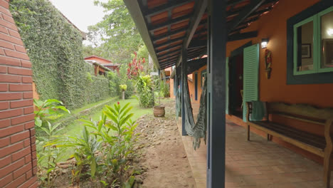 travelling-shot-of-beautiful-green-garden-with-hammocks-hanging-on-the-porch-at-rustic-villa