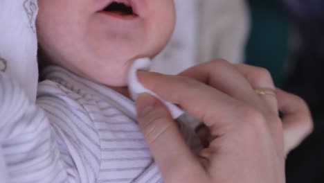 Mother's-hand-cleaning-crying-newborn-baby's-mounth---close-up