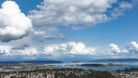 Wide-panning-aerial-shot-of-the-cloudy-and-blue-sky-above-Whidbey-Island's-Oak-Harbor