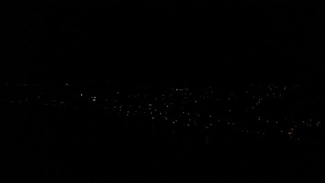 Luftaufnahme-über-Dem-Dunklen-Nachthimmel,-Blick-über-Die-Stadt-Estepona,-Wobei-Nur-Die-Lichter-Von-Gebäuden-Sichtbar-Sind