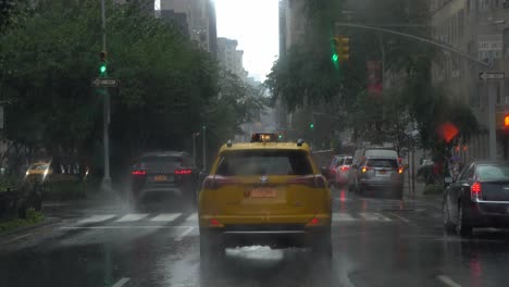 POV-driving-behind-a-yellow-taxi-in-rainy-Manhattan,-New-York-City