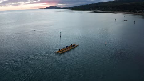 Descending-aerial-shot-of-an-outrigger-canoe-rowing-on-the-ocean-in-O'ahu,-Hawaii