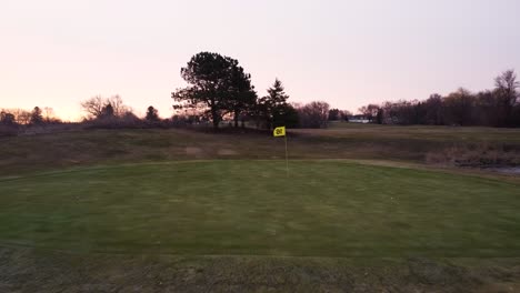 Tracking-shot-moving-forward-over-golf-course-during-sunrise
