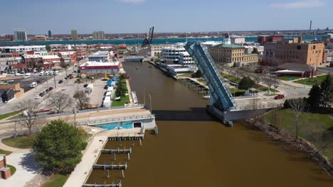 Boot-Auf-Dem-Fluss-Mit-Offener-Zugbrücke-Auf-Dem-Black-River-In-Port-Huron,-Michigan-Mit-Drohnenvideo,-Das-Sich-Vorwärts-Bewegt