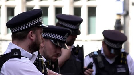 Metropolitan-police-officers-stand-in-a-group-during-a-public-order-event-in-slow-motion