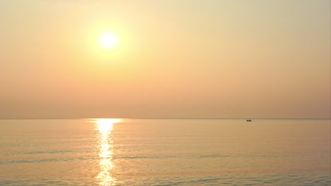 Goldener-Sonnenuntergang-über-Dem-Ruhigen-Ozean-Mit-Einem-Weit-Entfernten-Fischerboot