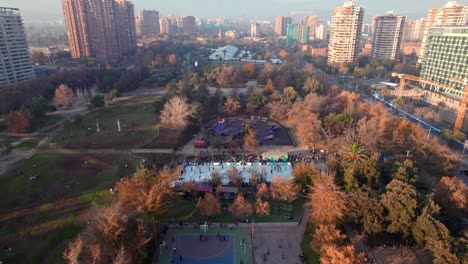 Dolly-in-tilt-up-aerial-view-of-Parque-Araucano-with-El-Plomo-hill-in-the-background,-Santiago,-Chile