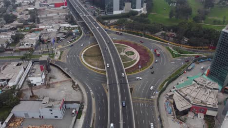 Drone-footage-of-newly-built-overpass-in-Lima,-Peru-above-a-roundabout-called-"Ovalo-Monitor-Huascar"-Cars-can-be-seen-driving-in-streets-with-little-traffic-on-cloudy-day