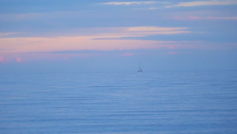Boat-Seen-In-Distance-Floating-In-Sea-Off-The-Costa-Del-Sol-During-Evening-Twilight-Hours