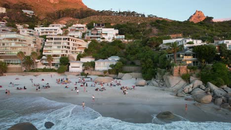 People-relaxing-on-a-Clifton-3rd-Beach-in-Cape-Town,-South-Africa-during-sunset,-aerial