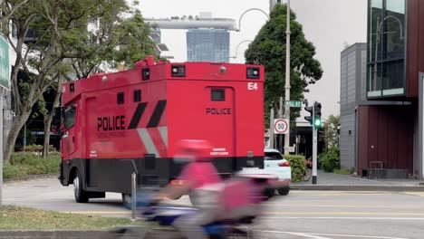 Two-red-tactical-vehicle-used-by-the-Special-Operations-Command-driving-on-hill-street,-elite-front-line-department-of-the-Singapore-Police-Force-