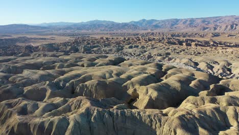 Aerial-flyover-Arroyo-Tapiado-Mud-Cave-Landscape-during-sunny-day-and-blue-sky-in-California
