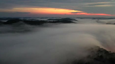 Drohnenschuss,-Der-In-Der-Abenddämmerung-über-Niedrigen-Nebelwolken-Fliegt