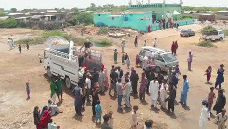 Eine-Schwenkaufnahme-Von-Flutopfern,-Die-Lebensmittel-Aus-Einem-Hilfsfahrzeug-In-Sindh-Sammeln