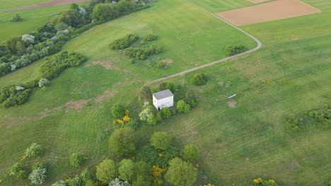 aerial-view-of-a-small-building-in-the-middle-of-the-green-meadows-of-the-hesse-area-in-germany