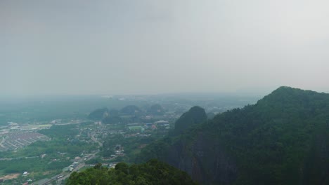 4K-Cinematic-landscape-scenic-footage-of-a-panoramic-view-of-the-town-of-Krabi-and-the-mountain-jungle-from-the-top-of-Wat-Tham-Suea,-Tiger-Cave-Temple-in-Krabi,-South-Thailand-on-a-sunny-day