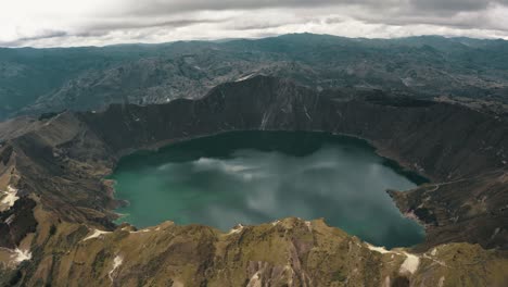 Drone-shot-of-beautiful-crater-lake-with-green-color-surrounded-by-volcano-in-Ecuador---Birds-eye-view