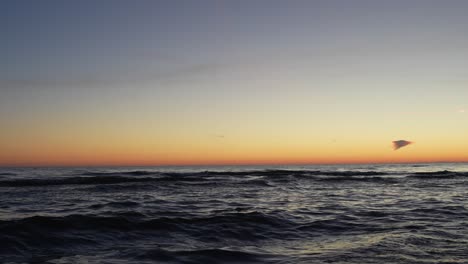 Majestic-orange-sunset-above-wavy-ocean-horizon,-static-view