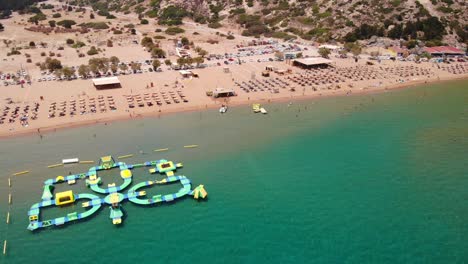 Inflatable-Island-At-Water-Park-In-Tsambika-Beach,-Greece
