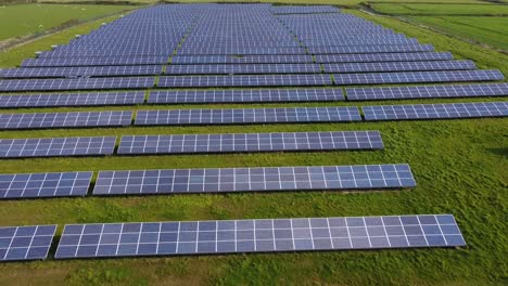 Flying-over-solar-farm-panels-looking-up-at-horizon-over-green-field