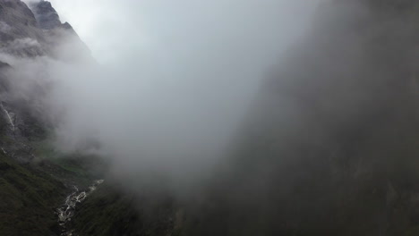 Aerial-drone-shot-through-foggy-weather-into-the-Annapurna-mountains,-Nepal