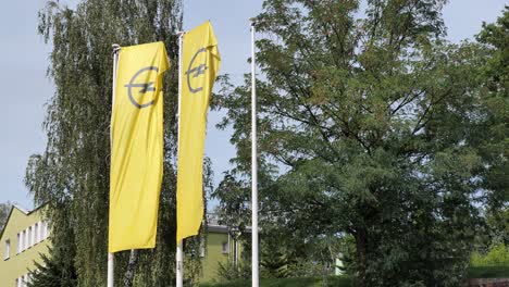 Opel-car-manufacturer-yellow-banners-waving-in-wide-at-dealership